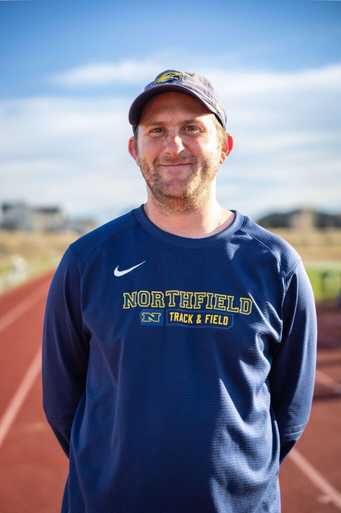 Coach Joey Bender headshot with track field in the background