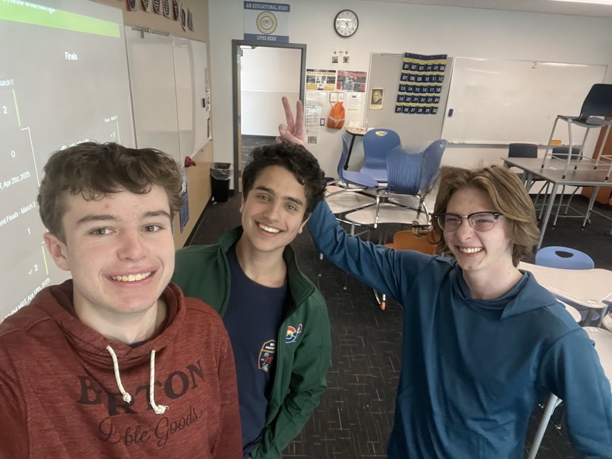 Three chess team students smiling at the camera.