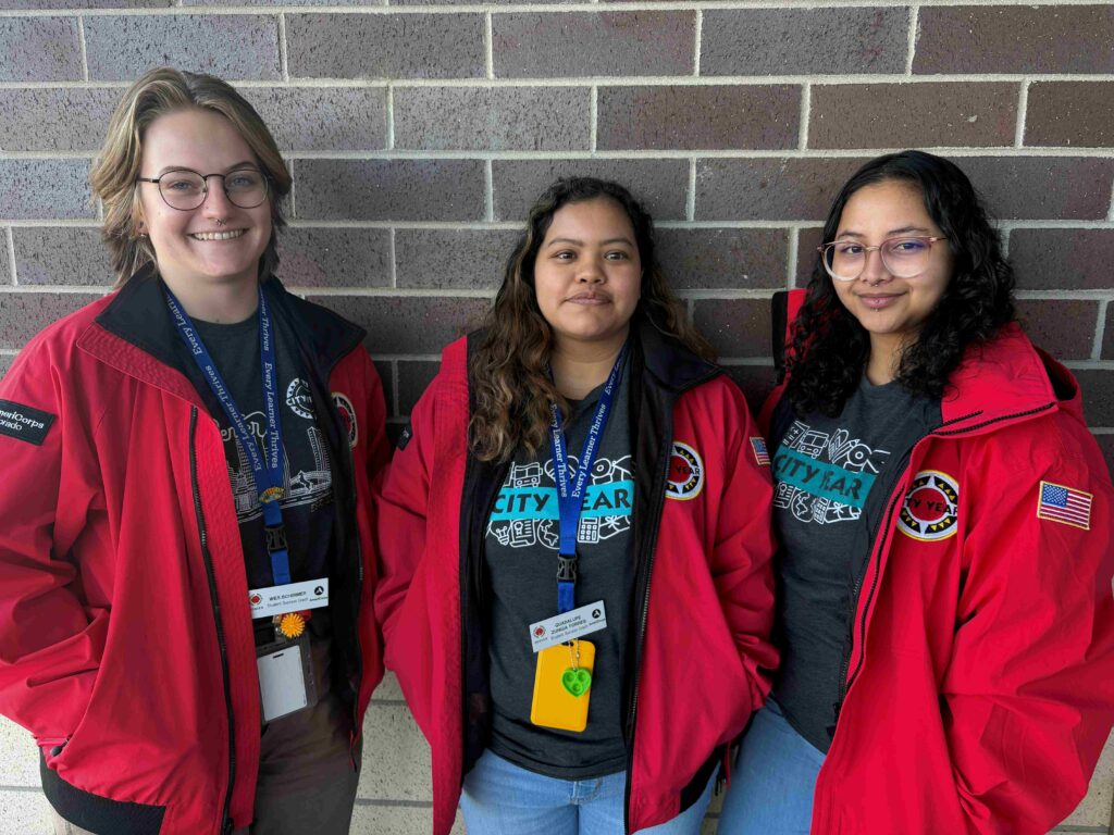 Picture of three members of the team standing against a brick wall.