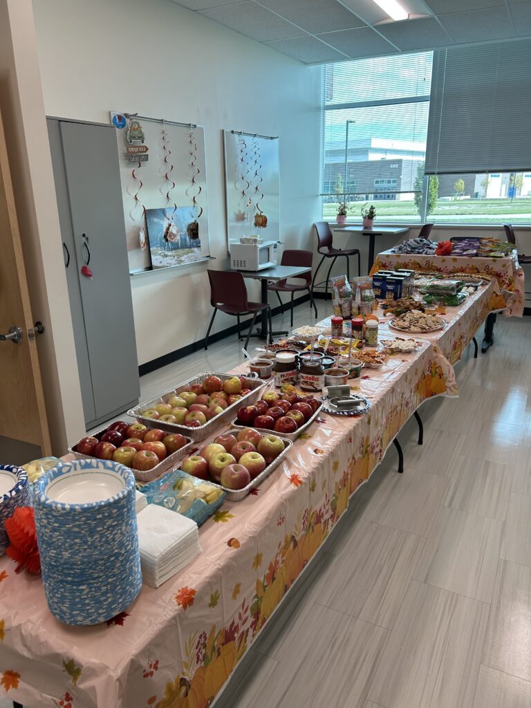 Three long tables filled with items that make up a Candy Apple Bar...apples, chocolate, caramel, nutella.